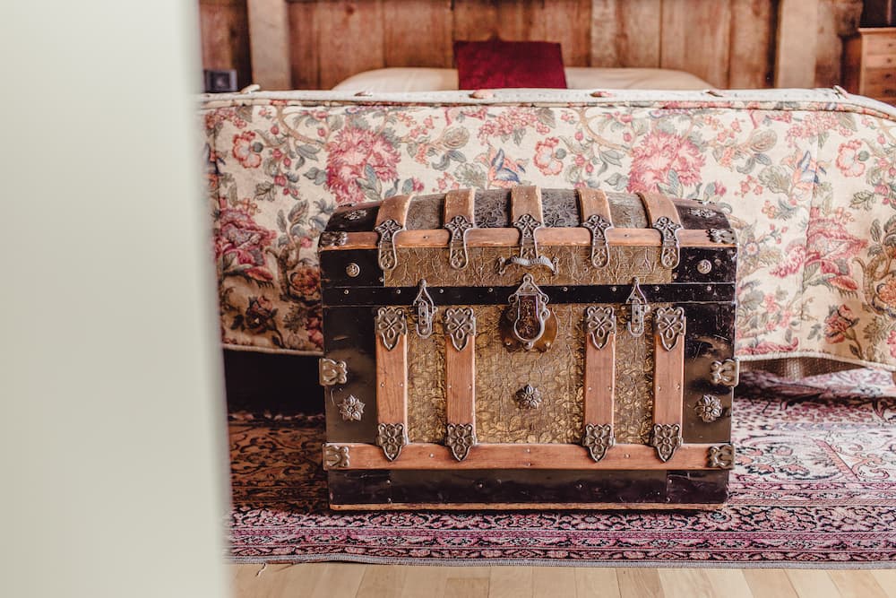 An antique chest sitting at the foot of the bed in the Apline Suite at Twin Pine Manor in Lancaster County, PA