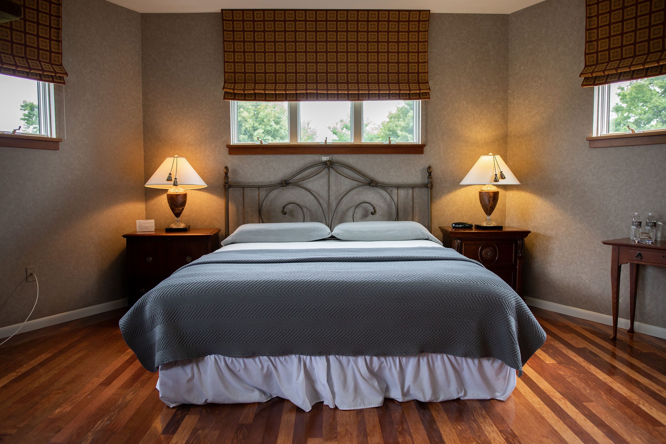 The Tower Suite's bedroom, complete with a Queen sized sofa bed, lamps on each side of the bed, and a window above for sunlight to creep through on a beautiful day.